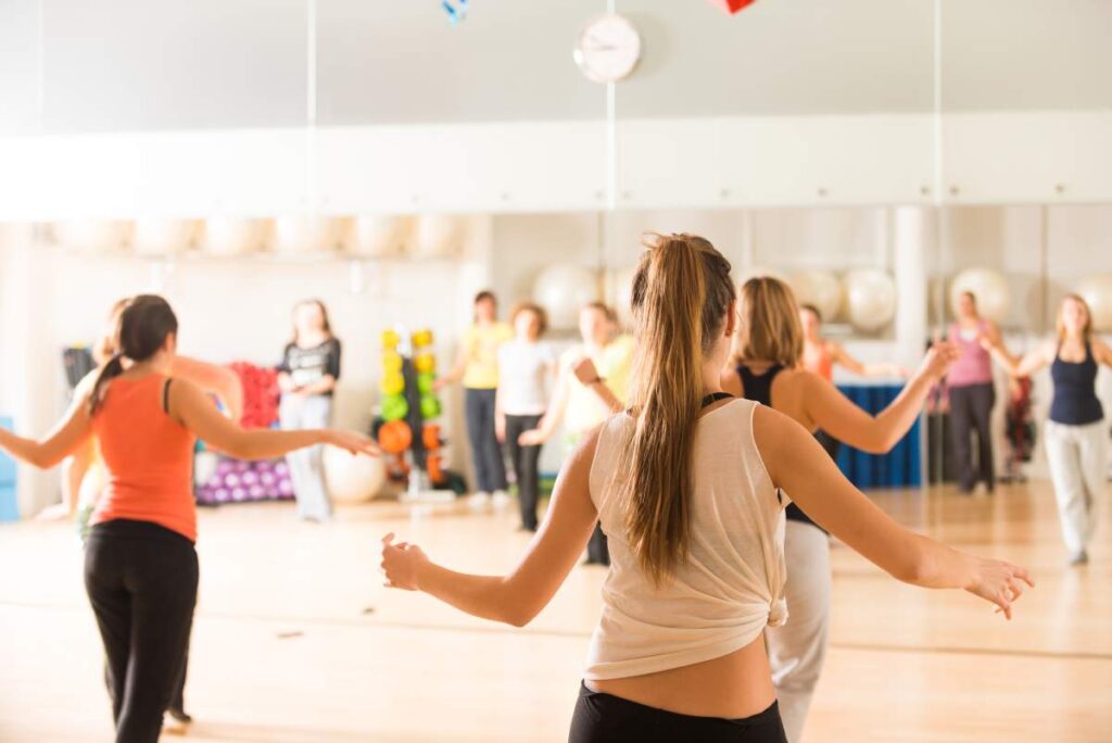 Couple practicing a slow ballroom dance in a bright indoor studio with relaxed posture and connected hands.