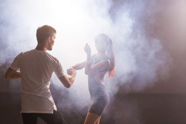 Couple practicing a choreographed first dance in formal shoes on a studio floor.