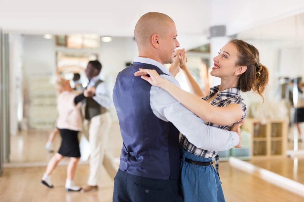 Couple practicing ballroom steps in comfortable clothing and smooth-soled dance shoes.
