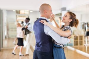 Couple practicing ballroom steps in comfortable clothing and smooth-soled dance shoes.